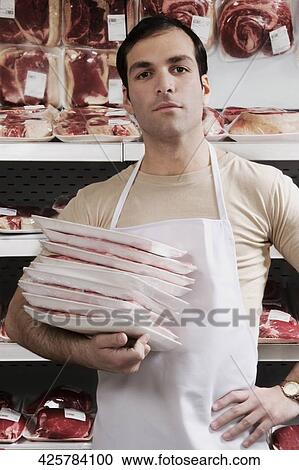 Portrait of a salesman holding meat packets View Large Photo Image Stock Image - Portrait of a salesman holding meat packets. Fotosearch