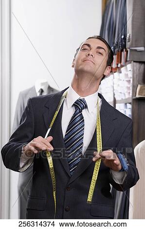 Portrait of a tailor holding a tape measure View Large Photo Image Picture - Portrait of a tailor holding a tape measure. Fotosearch