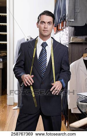 Portrait of a tailor holding a tape measure View Large Photo Image Stock Photo - Portrait of a tailor holding a tape measure. Fotosearch