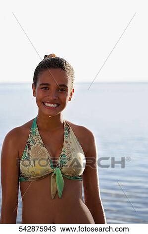 Stock Image - Portrait of a teenage girl smiling on the beach. Fotosearch