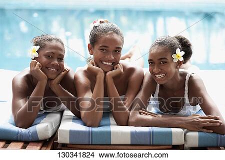 Portrait of a teenage girl with her friends sunbathing at the poolside View Large Photo Image Picture - Portrait of a teenage girl with her friends sunbathing at the poolside. Fotosearch