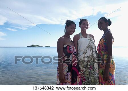 Stock Image - Portrait of a teenage girl with her friends smiling on the beach. Fotosearch