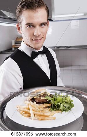 Portrait of a waiter holding a tray of snacks View Large Photo Image Stock Photography - Portrait of a waiter holding a tray of snacks. Fotosearch