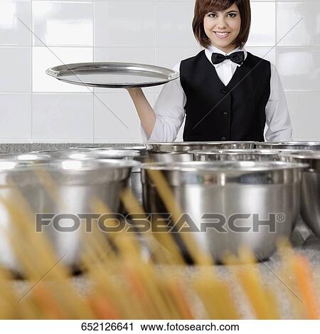 Portrait of a waitress holding a tray View Large Photo Image Stock Image - Portrait of a waitress holding a tray. Fotosearch