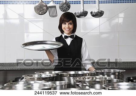 Stock Photo - Portrait of a waitress holding a tray. Fotosearch