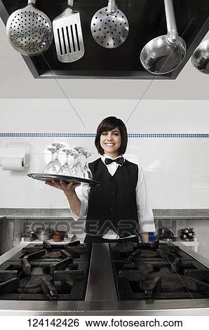 Portrait of a waitress holding a tray of glasses View Large Photo Image Stock Photograph - Portrait of a waitress holding a tray of glasses. Fotosearch