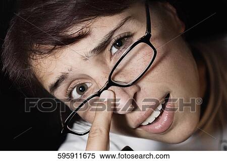 Portrait of a woman adjusting her eyeglasses View Large Photo Image Stock Photography - Portrait of a woman adjusting her eyeglasses. Fotosearch