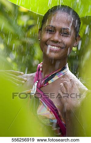Stock Photo - Portrait of a woman enjoying rain shower. Fotosearch