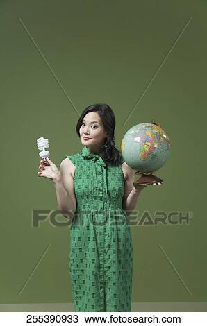 Portrait of a woman holding a globe and a light bulb View Large Photo Image Stock Image - Portrait of a woman holding a globe and a light bulb. Fotosearch