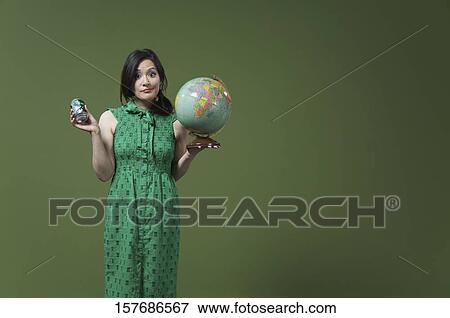 Portrait of a woman holding a globe and a beer can View Large Photo Image Stock Photo - Portrait of a woman holding a globe and a beer can. Fotosearch