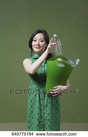 Portrait of a woman holding a recycling bin View Large Photo Image Picture - Portrait of a woman holding a recycling bin. Fotosearch
