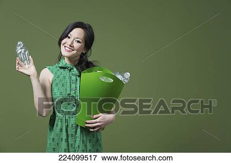 Portrait of a woman holding a recycling bin View Large Photo Image Stock Photo - Portrait of a woman holding a recycling bin. Fotosearch