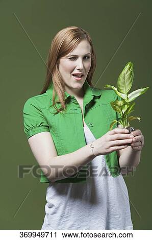 Portrait of a woman holding a seedling View Large Photo Image Stock Image - Portrait of a woman holding a seedling. Fotosearch