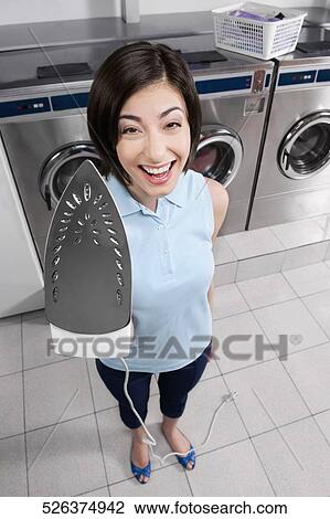 Portrait of a woman holding iron and smiling View Large Photo Image Stock Image - Portrait of a woman holding iron and smiling. Fotosearch