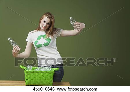 Stock Image - Portrait of a woman holding plastic bottles. Fotosearch