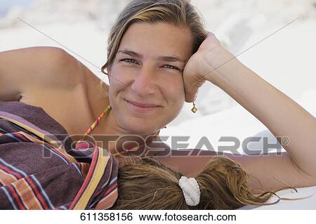 Stock Photograph - Portrait of a woman resting on the beach with her daughter, Cabo San Lucas, Mexico. Fotosearch