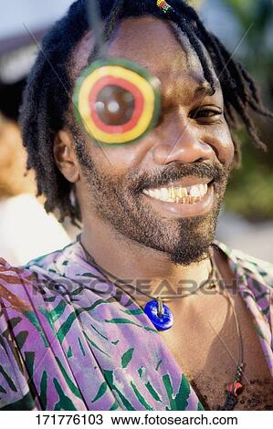 Portrait of a young man smiling with a necklace over his eye View Large Photo Image Stock Image - Portrait of a young man smiling with a necklace over his eye. Fotosearch