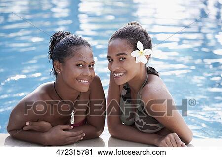 Stock Image - Portrait of two female friends smiling in a swimming pool. Fotosearch
