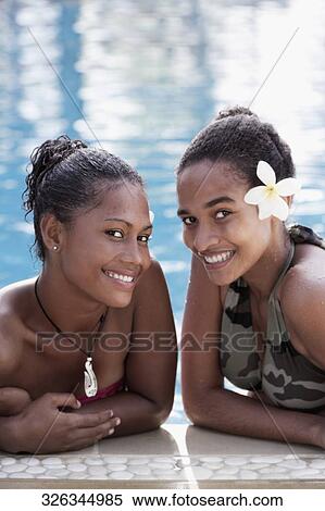 Portrait of two female friends smiling in a swimming pool View Large Photo Image Stock Photography - Portrait of two female friends smiling in a swimming pool. Fotosearch