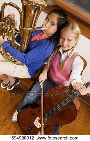 Portrait of two girls playing violin and tuba in a class View Large Photo Image Stock Image - Portrait of two girls playing violin and tuba in a class. Fotosearch