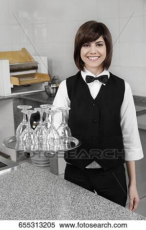 Stock Photography - Portrait of waitress holding a tray of glasses. Fotosearch