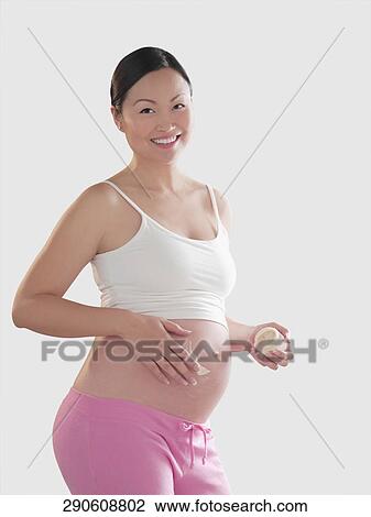 Pregnant woman applying moisturizer on her abdomen View Large Photo Image Stock Image - Pregnant woman applying moisturizer on her abdomen. Fotosearch