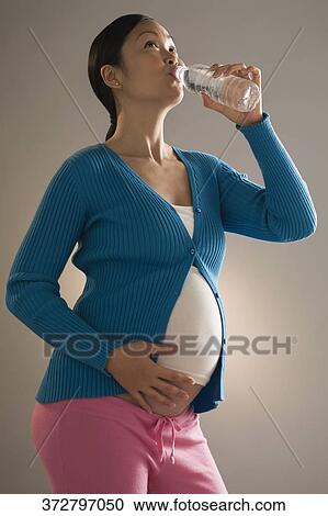 Pregnant woman drinking water View Large Photo Image Stock Image - Pregnant woman drinking water. Fotosearch