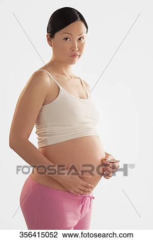 Pregnant woman holding a cigarette on her abdomen View Large Photo Image Stock Image - Pregnant woman holding a cigarette on her abdomen. Fotosearch