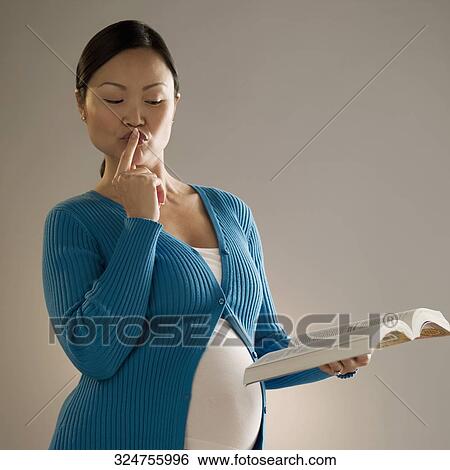 Stock Photograph - Pregnant woman reading a book. Fotosearch