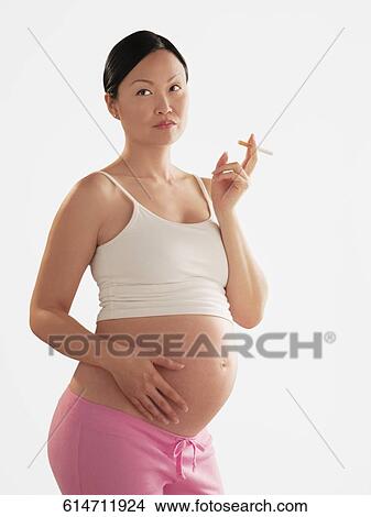 Picture - Pregnant woman smoking a cigarette. Fotosearch
