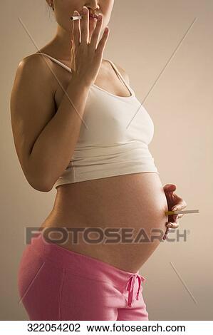 Pregnant woman smoking a cigarette View Large Photo Image Stock Image - Pregnant woman smoking a cigarette. Fotosearch