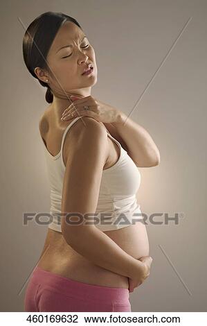 Stock Image - Pregnant woman suffering from backache. Fotosearch