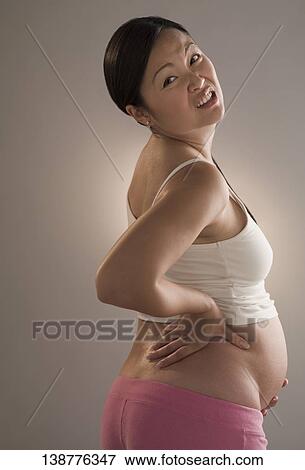 Stock Photo - Pregnant woman suffering from backache. Fotosearch