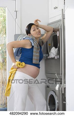Pregnant woman washing clothes and looking tired View Large Photo Image Stock Image - Pregnant woman washing clothes and looking tired. Fotosearch