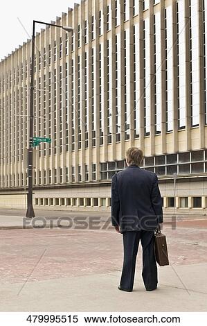 Stock Photography - Rear view of a businessman standing with a briefcase. Fotosearch
