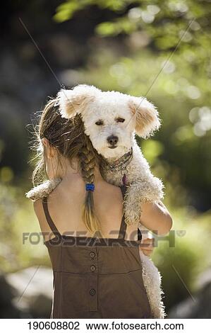 Rear view of a girl carrying her dog View Large Photo Image Stock Image - Rear view of a girl carrying her dog. Fotosearch