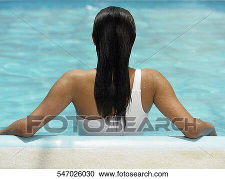 Rear view of a woman leaning against the side of a swimming pool View Large Photo Image Stock Image - Rear view of a woman leaning against the side of a swimming pool. Fotosearch