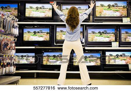 Rear view of a woman standing in an electronics store View Large Photo Image Stock Photograph - Rear view of a woman standing in an electronics store. Fotosearch