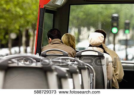 Rear view of four people traveling on the top deck of a tour bus, Madrid, Spain View Large Photo Image Stock Image - Rear view of four people traveling on the top deck of a tour bus, Madrid, Spain. Fotosearch