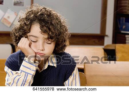 Sad schoolboy sitting in a classroom View Large Photo Image Stock Photo - Sad schoolboy sitting in a classroom. Fotosearch