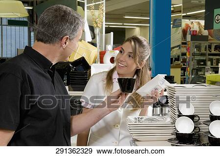 Sales clerk assisting a customer choosing crockery in a supermarket View Large Photo Image Stock Photo - Sales clerk assisting a customer choosing crockery in a supermarket. Fotosearch
