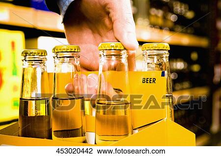 Sales clerk carrying up a crate of beer bottles View Large Photo Image Stock Image - Sales clerk carrying up a crate of beer bottles. Fotosearch