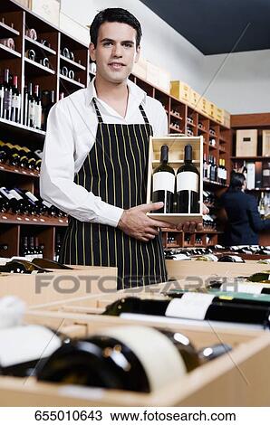 Sales clerk holding a crate of wine bottles View Large Photo Image Stock Image - Sales clerk holding a crate of wine bottles. Fotosearch