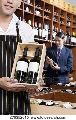 Sales clerk holding a crate of wine bottles View Large Photo Image Stock Photography - Sales clerk holding a crate of wine bottles. Fotosearch