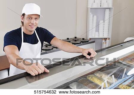 Stock Image - Sales clerk in an ice cream parlor. Fotosearch