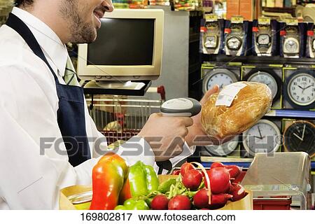 Sales clerk scanning the price of a bread with a bar code reader View Large Photo Image Stock Photo - Sales clerk scanning the price of a bread with a bar code reader. Fotosearch