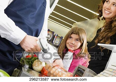 Sales clerk selling products to a costumer in a supermarket View Large Photo Image Stock Photo - Sales clerk selling products to a costumer in a supermarket. Fotosearch