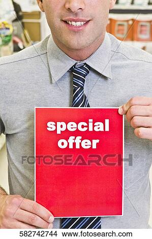 Sales clerk showing a Special Offer sign in a supermarket View Large Photo Image Picture - Sales clerk showing a Special Offer sign in a supermarket. Fotosearch