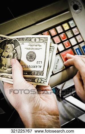 Stock Photo - Sales clerk using a cash register at a checkout counter. Fotosearch