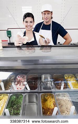 Sales clerks smiling in an ice cream parlor View Large Photo Image Picture - Sales clerks smiling in an ice cream parlor. Fotosearch